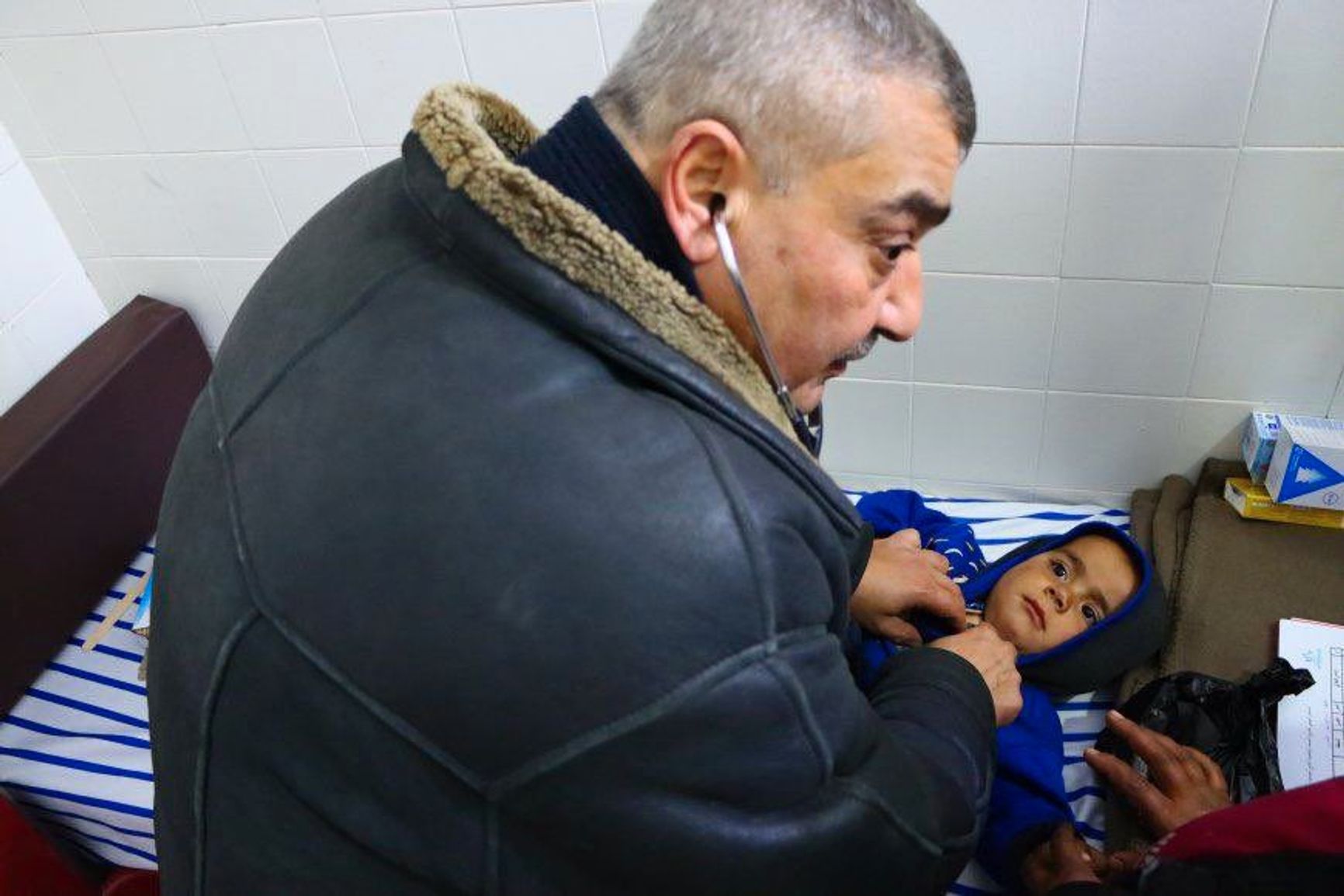 A doctor examines a child in a refugee camp in the settlement of Tabqa.