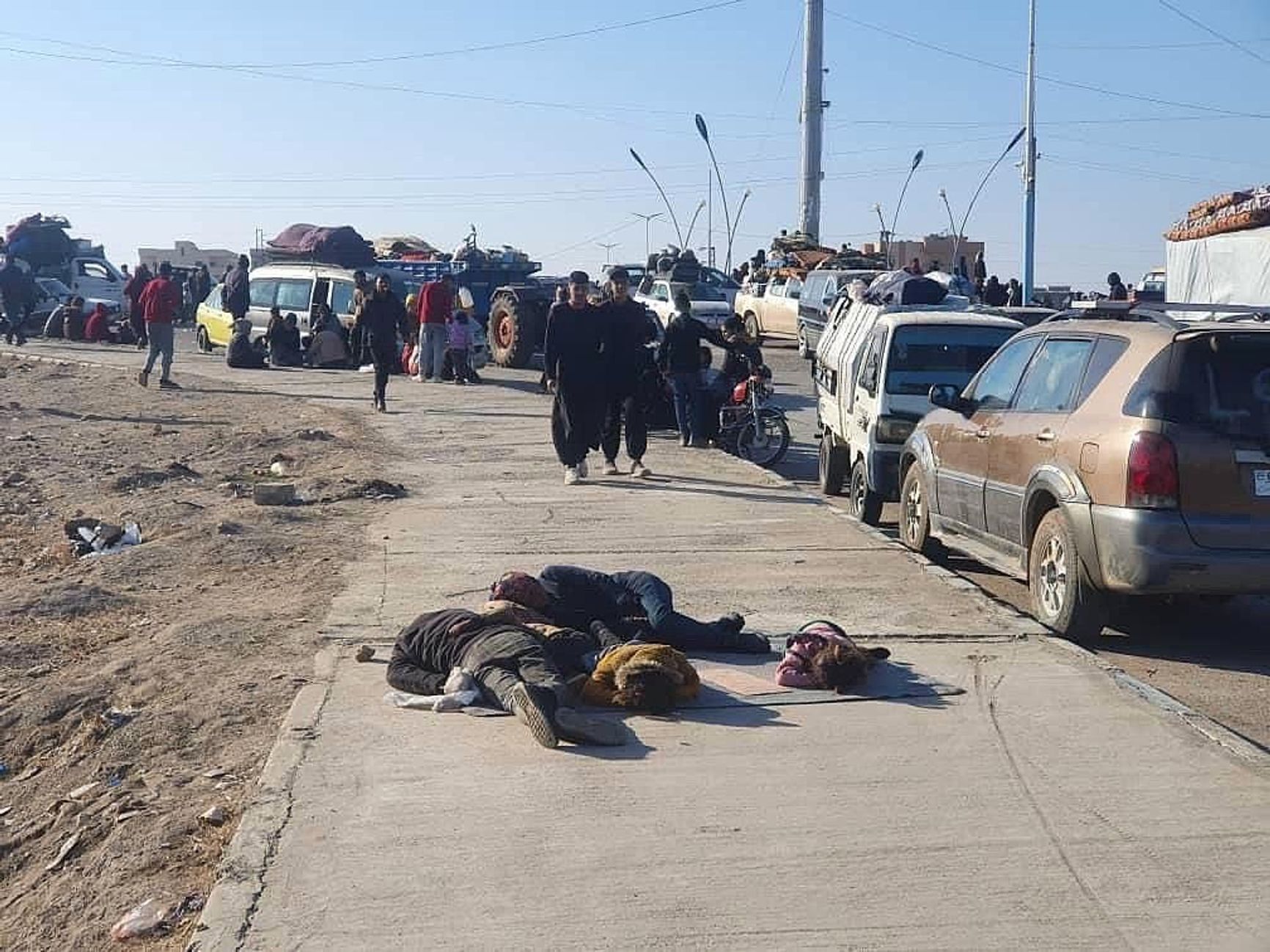 Refugees from Aleppo sleep on the road in the settlement of Tabqa, Raqqa province.